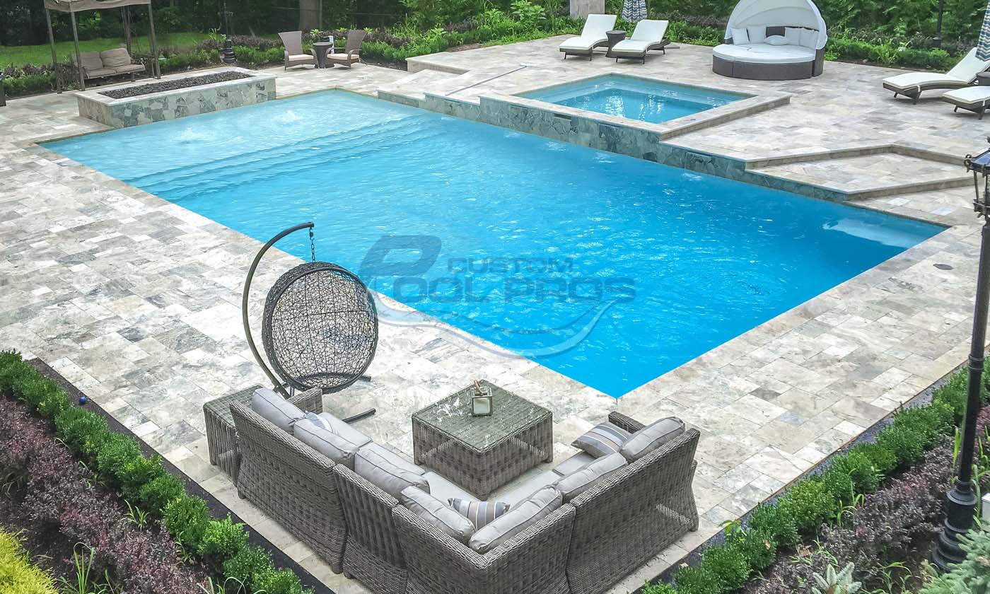 Luxury backyard pool area featuring a large swimming pool, a spa, and stylish outdoor seating with a modern design. The tranquil setting includes lush greenery and elegant lounge chairs, perfect for relaxation and entertaining.