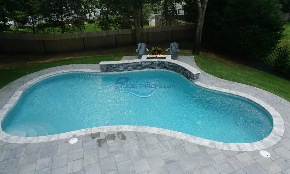 freeform gunite inground pool with fire pit sitting area and retaining wall, custom swimming pools